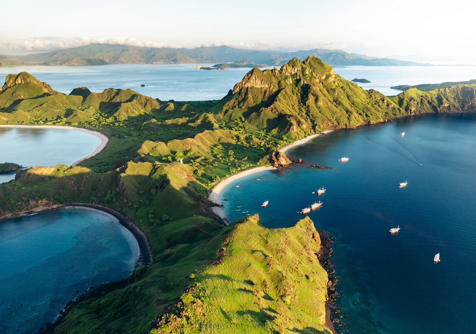 Aerial panorama of the turquoise water and green hills around Padar Island's bays