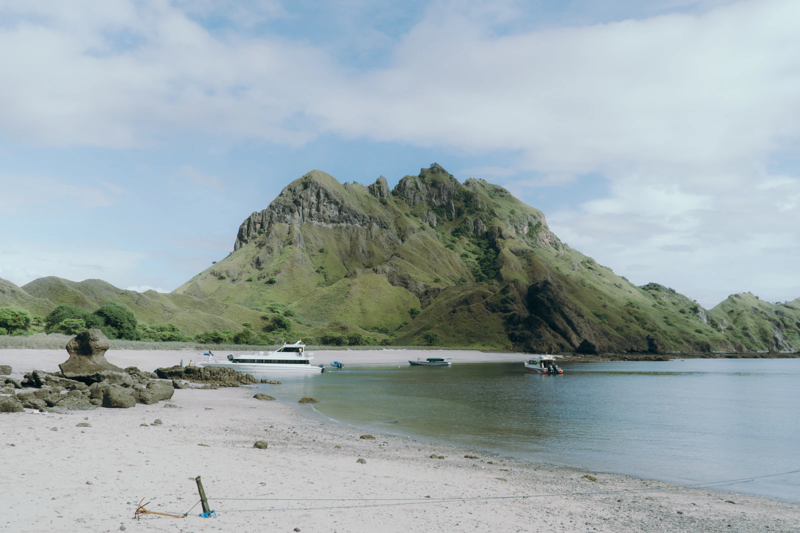 A small sandy beach with Padar Island's hills in the background