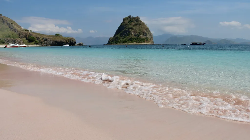 Pink-tinged sand beach in Komodo National Park meeting clear turquoise water