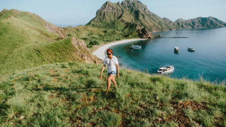 Visitors walking the grassy path towards the viewpoint on Padar Island
