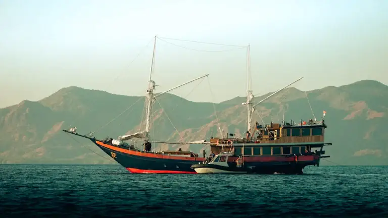 A phinisi boat floating on calm water near Labuan Bajo