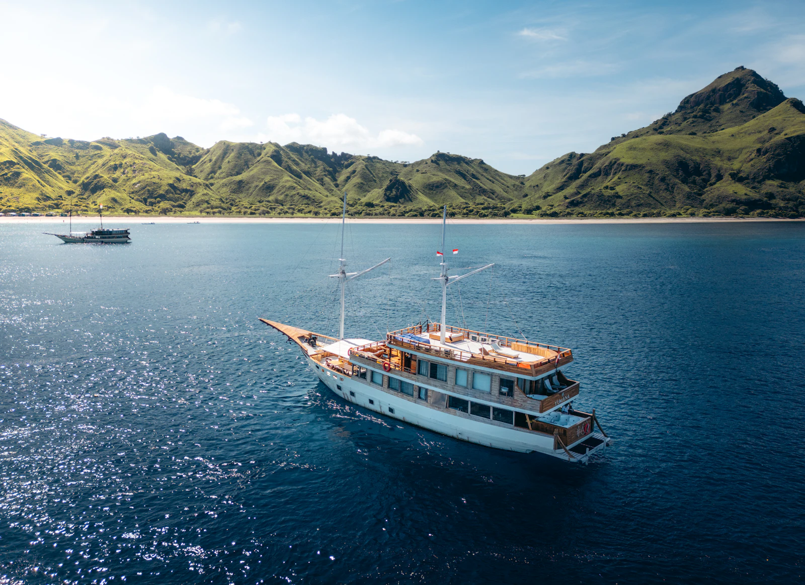 A luxury phinisi liveaboard sailing in the waters of Komodo National Park